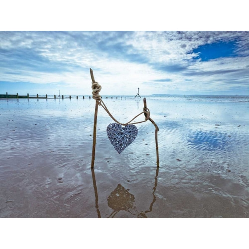Heart tied up on wooden sticks at the beach