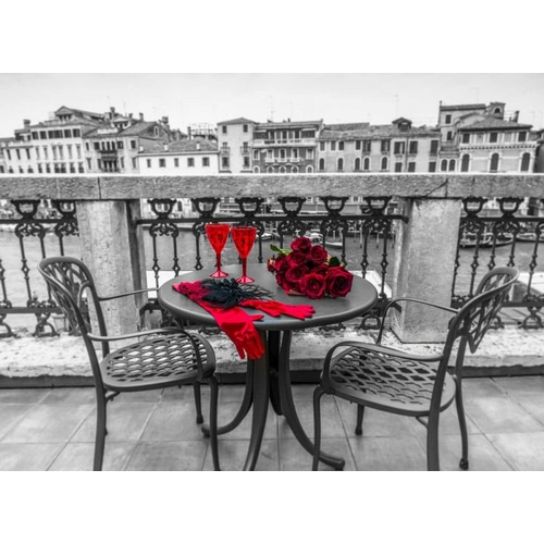 Bunch of Roses with wine glasses and female hand gloves on cafe table, Venice, Italy