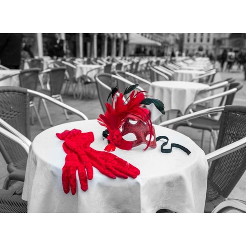 Female hand gloves with Venetian mask on cafe table, Venice, Italy
