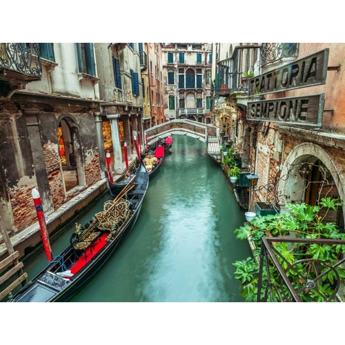 Gondola in narrow canal through old buildings, Venice, Italy