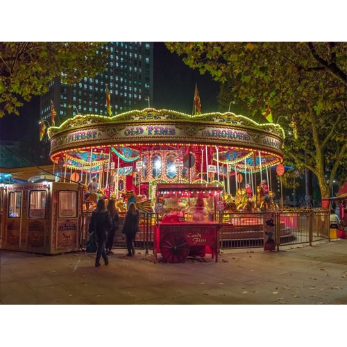 Spinning carousel at night in garden, London, UK