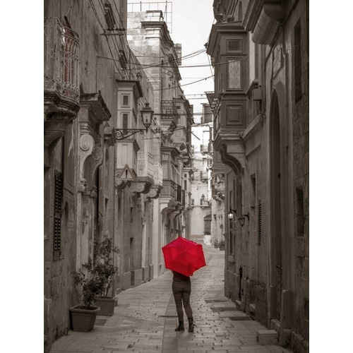 Tourist with umbrella at narrow street on Birgu, Malta