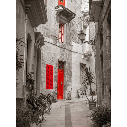 Narrow street through traditional maltese houses in Birgu, Malta