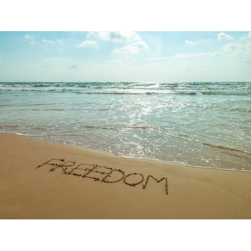 Word Freedom written in sand on the beach