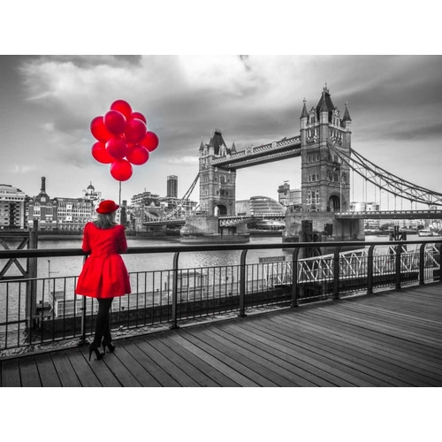 Woman with red balloons, standing on promenade near Tower Bridge, London, UK