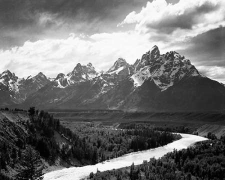 View from river valley towards snow covered mountains, river in foreground, Grand Teton National Par
