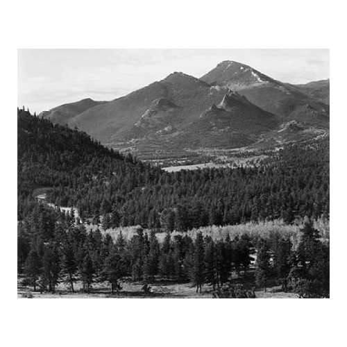 View with trees in foreground, barren mountains in background, in Rocky Mountain National Park, Colo