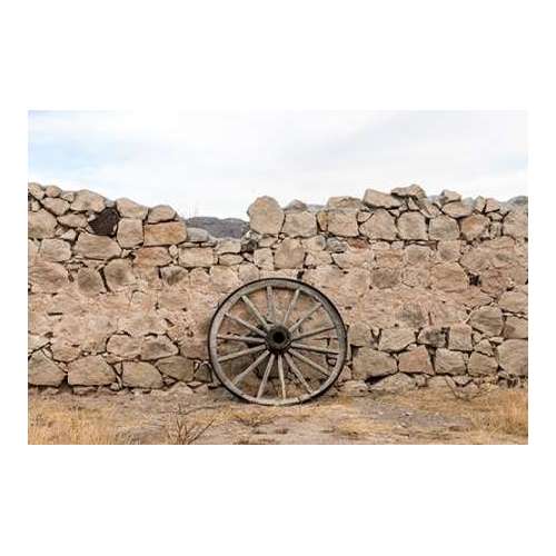 Wagon wheel against a stone fence at Hueco Tanks State Park, northwest of El Paso, TX