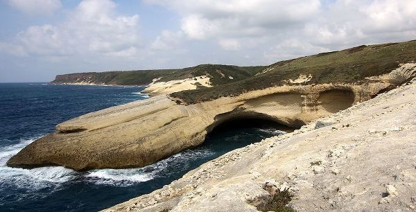 Flat rocks with natural arch on the coast of Sardinia Island