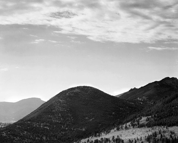 View of hill with trees, clouded sky, in Rocky Mountain National Park, Colorado, ca. 1941-1942