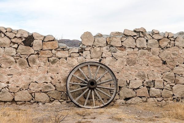 Wagon wheel against a stone fence at Hueco Tanks State Park, northwest of El Paso, TX