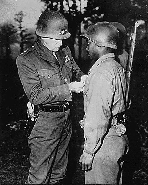 WWII Lt. Gen. George S. Patton-U.S. Third Army commander-pins the Silver Star on Private Ernest A. J